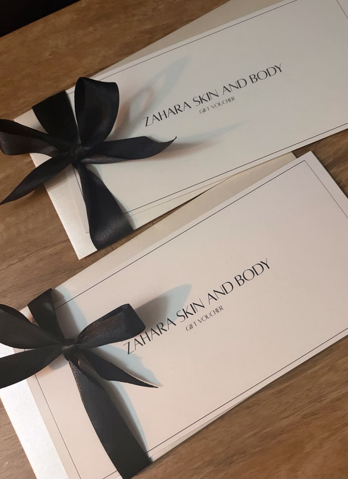 Two ZAHARA gift vouchers, each tied with a black ribbon